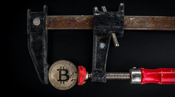 black-and-red-caliper-on-gold-colored-bitcoin-1099339